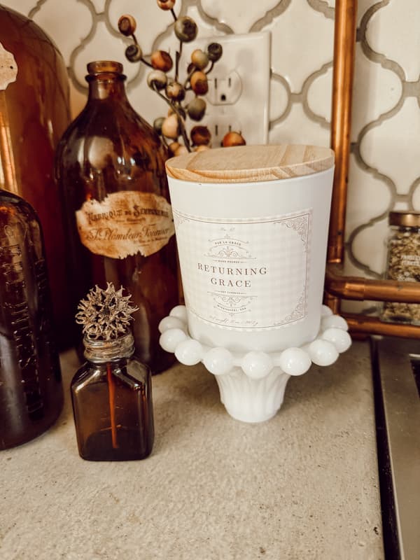 Returning Grace Signature Candle with vintage amber bottles 