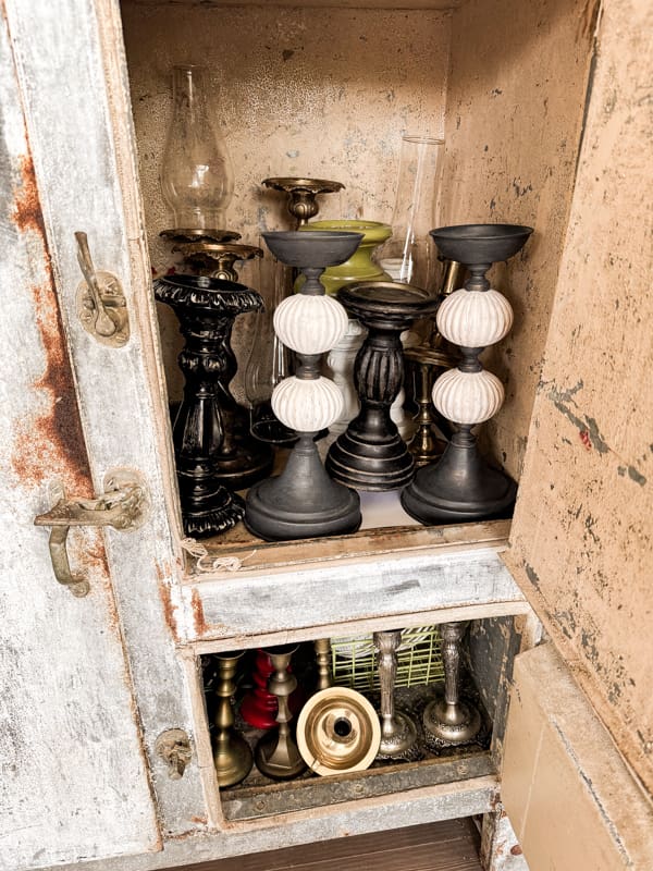 Old metal icebox is great for storing other tableware like unused candlestick holders.  