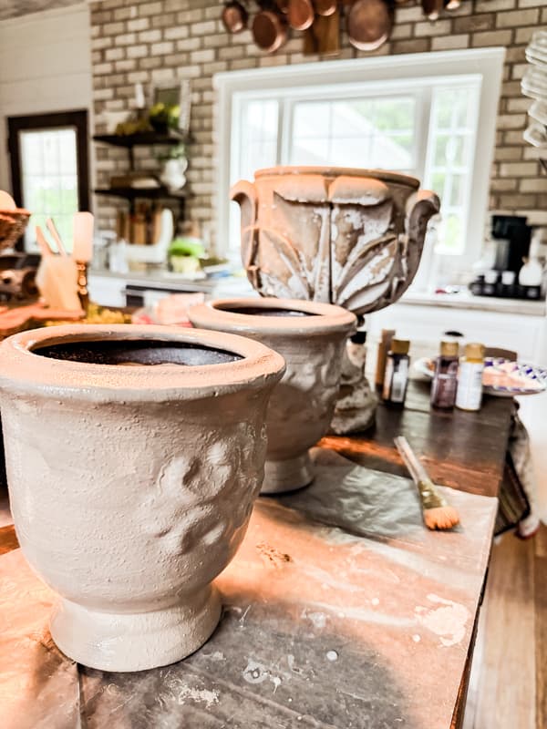 two vase painted beige with inspiration vessel in background