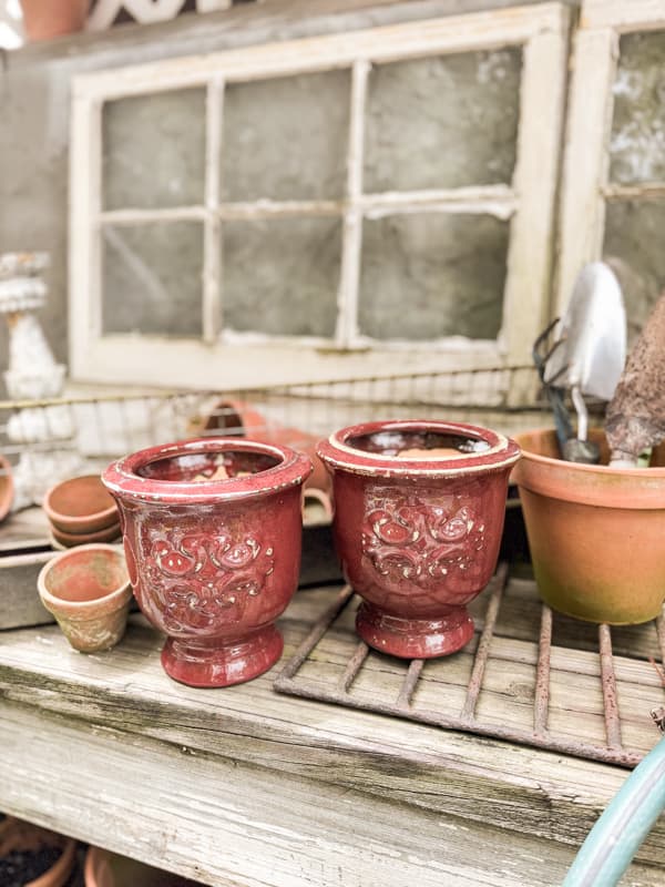 Outdated Thrift store Vases on potting bench.  