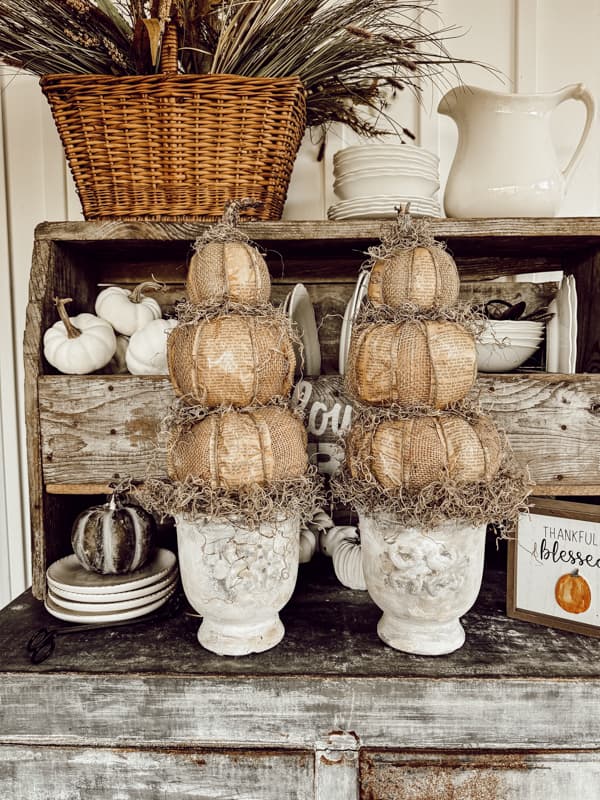 DIY Pumpkin Topiaries with Dollar Tree Pumpkins, burlap and old book pages on vintage metal ice box. Primitive Fall Craft