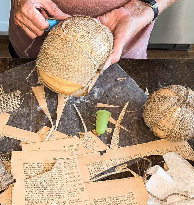 Wrap burlap pumpkins with jute twine to hold the old book pages in place.  