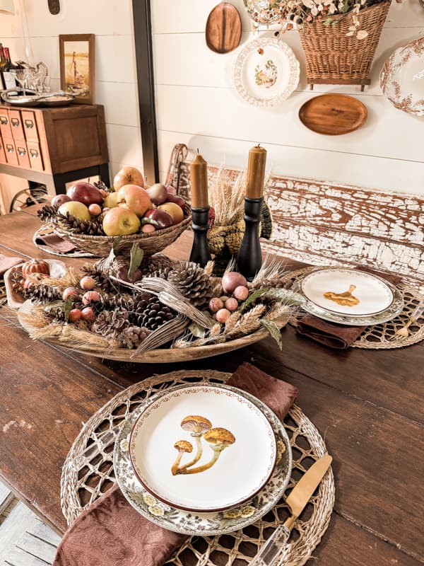 Dining table with mushroom plates, dried natural elements in dough bowl for Budget-Friendly Fall Decorating tips and  ideas