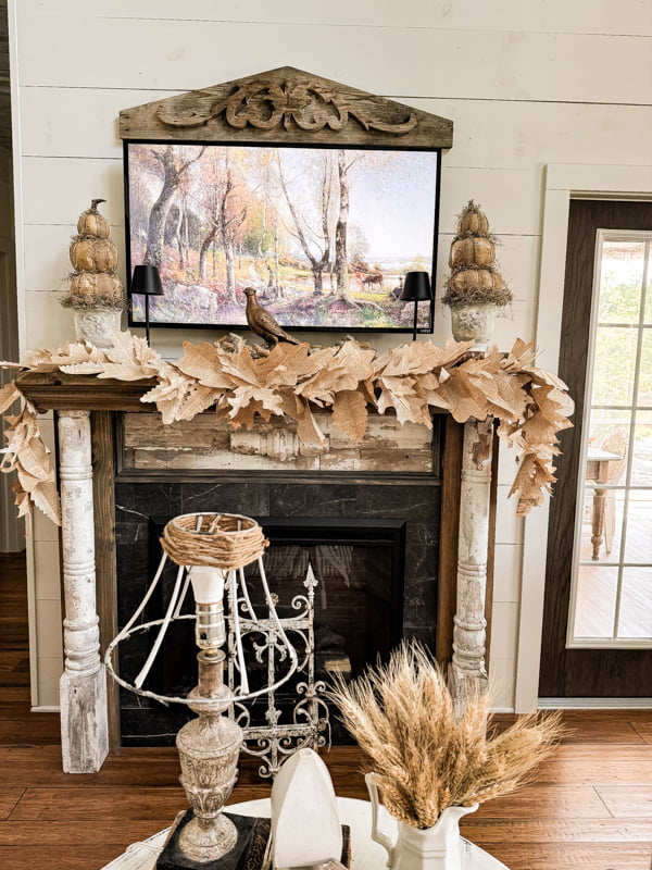 Fall mantel with DIY primitive pumpkin topiaries and leaf garland made from old book pages for fall decorating tips. 