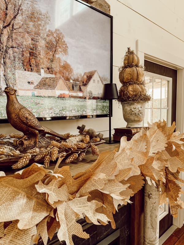 Fall mantel decorations with DIY fall mantel garland made from old book pages for rustic fall mantel ideas. 