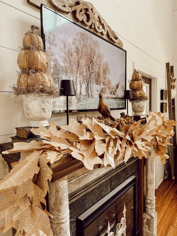 Fall mantel decorations with DIY fall mantel garland made from old book pages for rustic fall mantel ideas. 