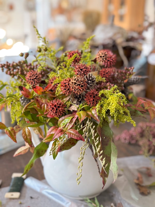 Easy DIY wildfower arrangement with sweet gum balls, golden rod and fall foliage.