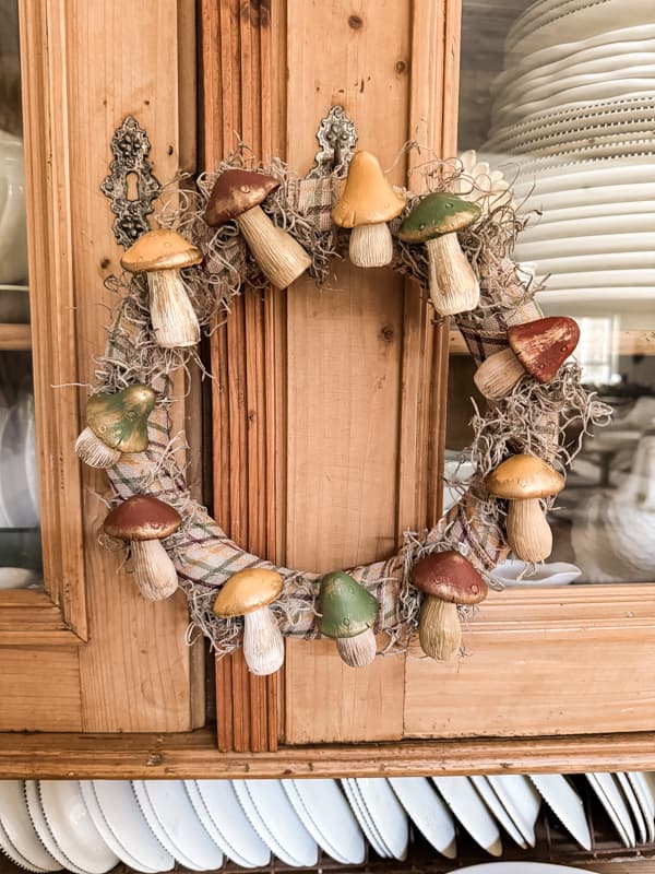 Mushroom Wreath Craft from Dollar Tree on hutch cabinet doors.  