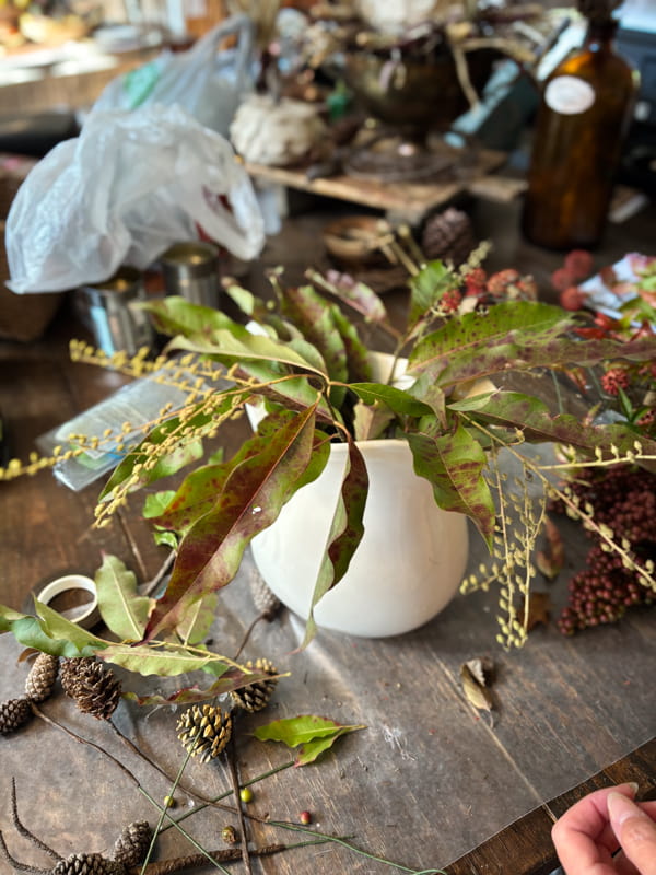 Add fall foliage to white ironstone pitcher for a fall floral arrangement