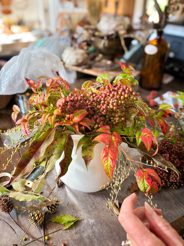 Add fall nandina berries to white ironstone pitcher for a fall floral arrangement