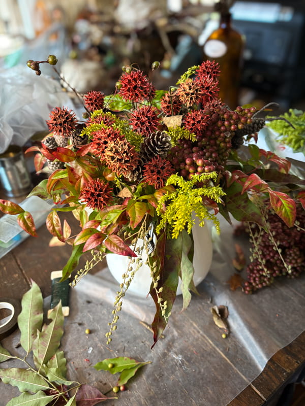 Add sweet gum ball stems and pinecone stems  to white ironstone pitcher for a fall floral arrangement