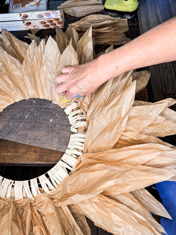 Hot glue bundles of faux corn husk leaves to wreath frame. 