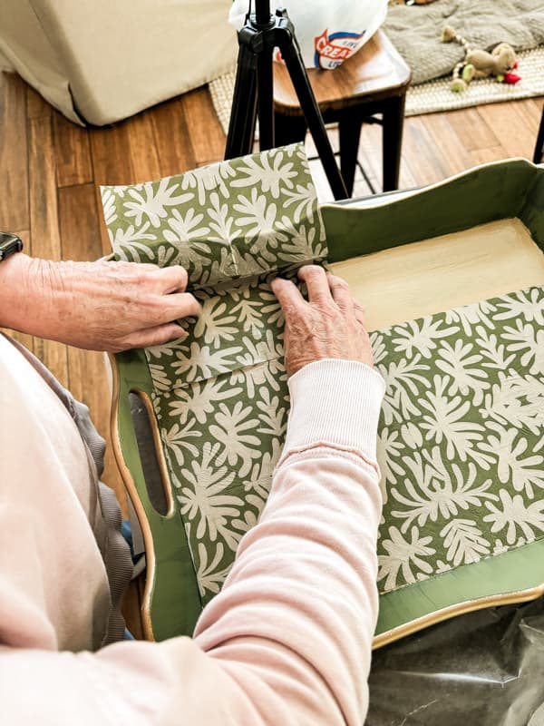 Align the napkin to fit in the bottom of the decorative wood tray