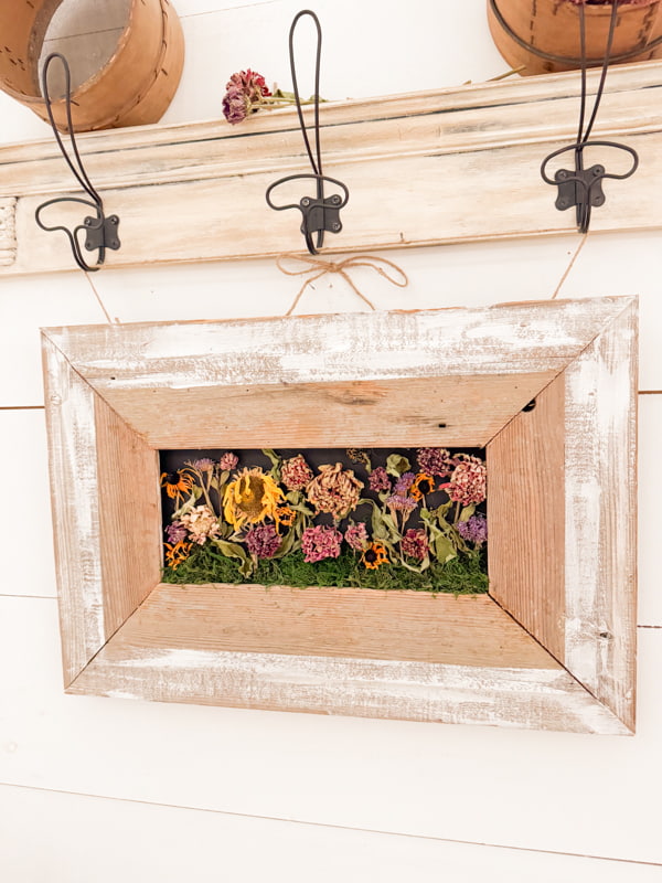 Dried Flowers in a DIY reclaimed shiplap frame hanging on a drying rack with more dried flowers