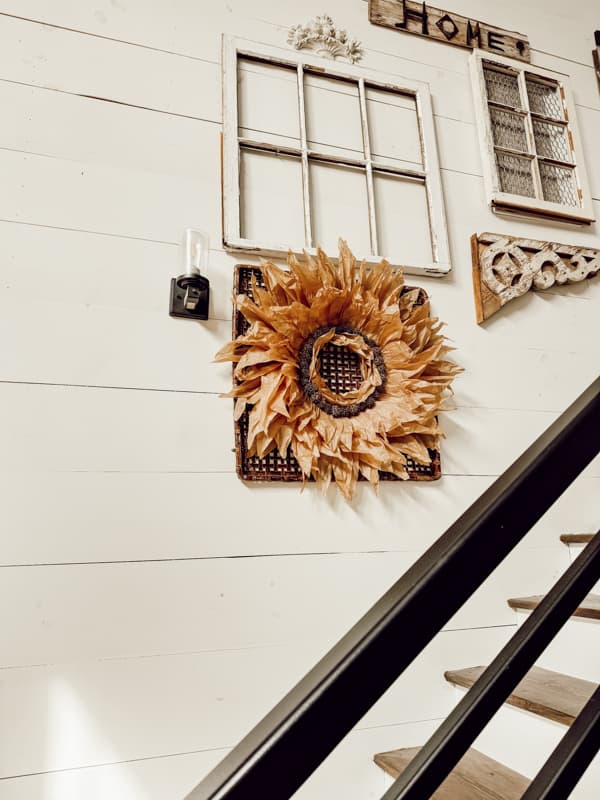 DIY Corn Husk Wreath with sweet gum balls on wall basket on gallery wall.