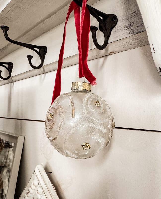 Easy DIY Christmas Ornaments made with hot glue and glitter on a red ribbon.