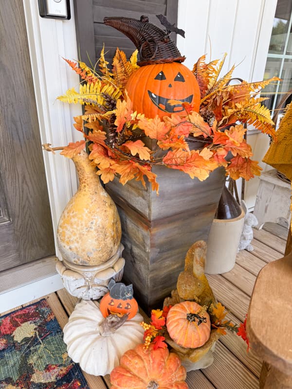 Halloween porch decorations with pumpins and dried gourds.  