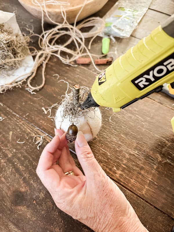 Add acorns to the pumpkin craft with hot glue