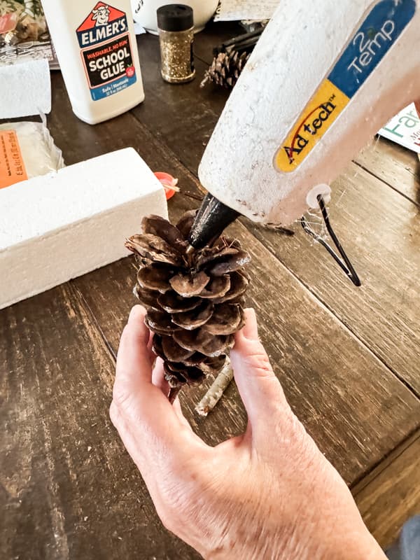 Add hot glue to bottom of pinecone.