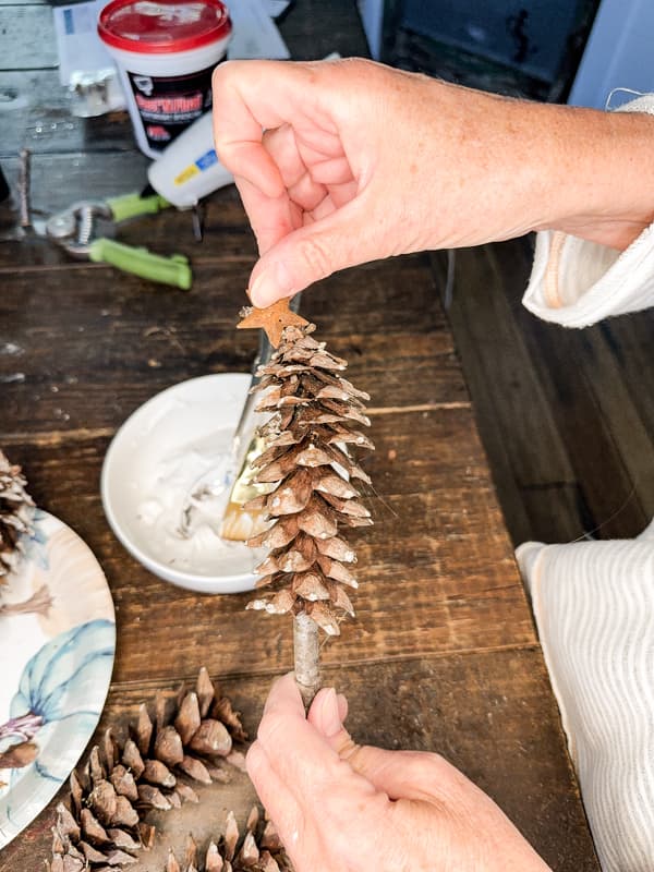 add metal rustic star to top of pinecone tree.