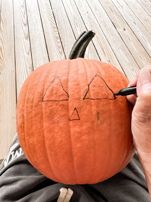 Draw Jack O' Llantern face on pumpkin