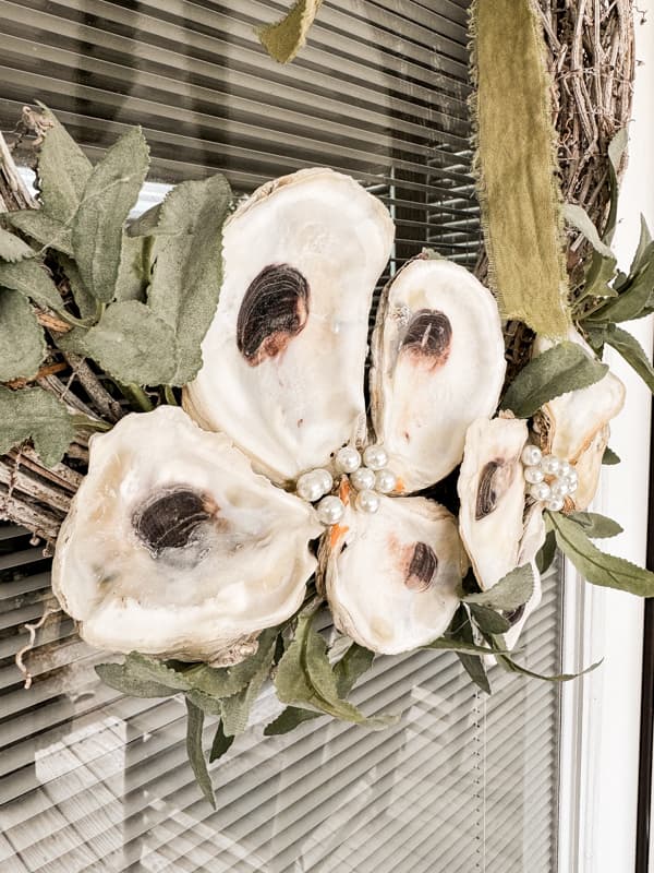 Close up of oyster shell decor wreath on beach cottage door.