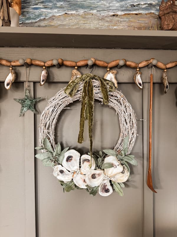 DIY Christmas Wreath with Upcycled Oyster Shell Craft on accent wall.  