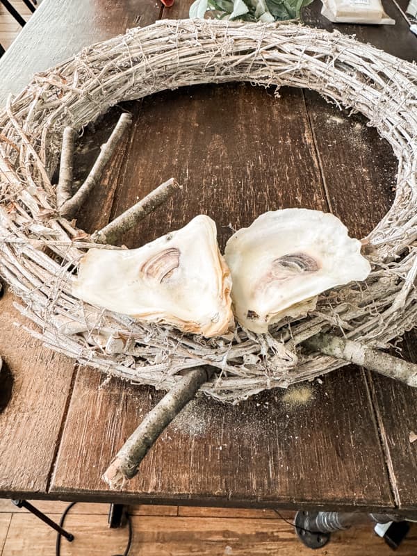 add twigs to recycled grapevine wreath to support the oyster shells