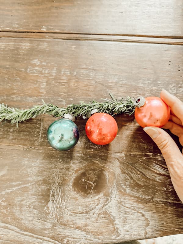 Add vintage glass ornaments to greenery garland tie to add to wall arrangemnt.  