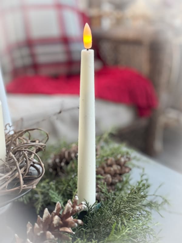 Flicker candle on advent wreath in screened porch.