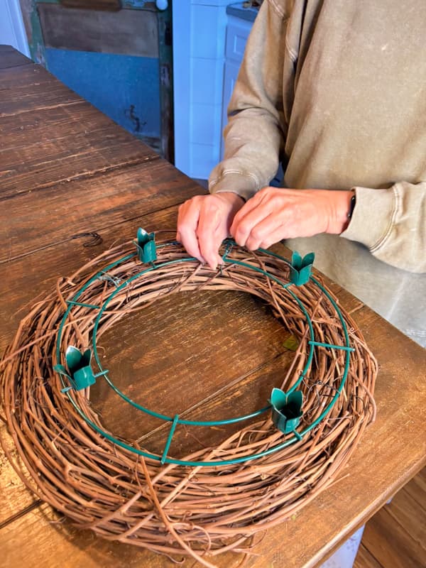 attach the advent wreath frame to the grapevine wreath with wire ties.