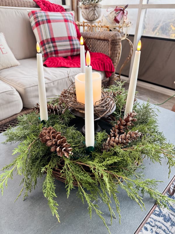 DIY Advent Wreath with flicker candles on screen porch coffee table.  A pinecone Christmas Craft with real cedar greenery