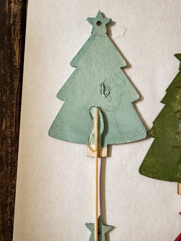 Add a long toothpick to back of Christmas trees with permanent glue.  