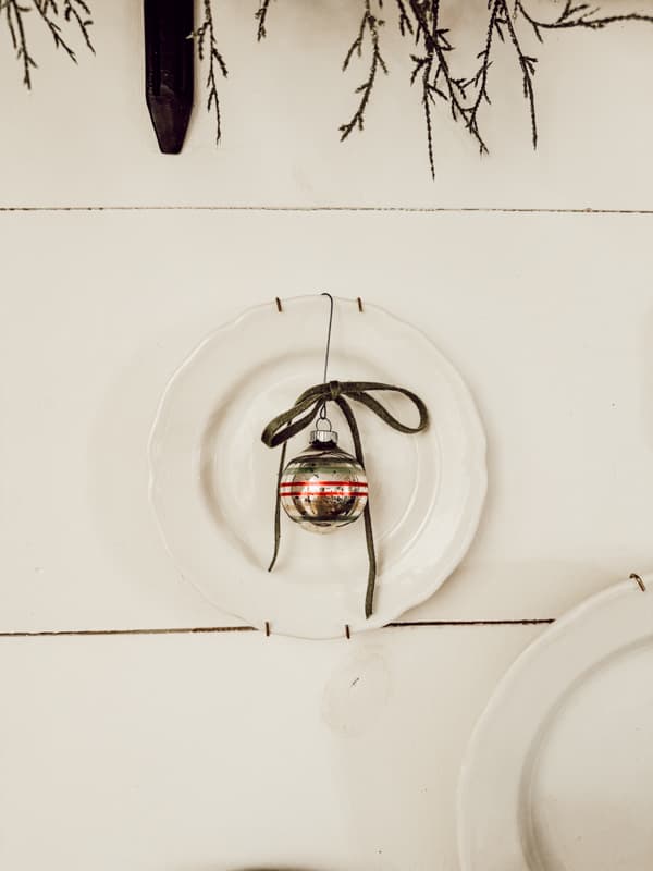 Retro Christmas Decor with ironstone place and shiny brite ornament on dining room wall.  