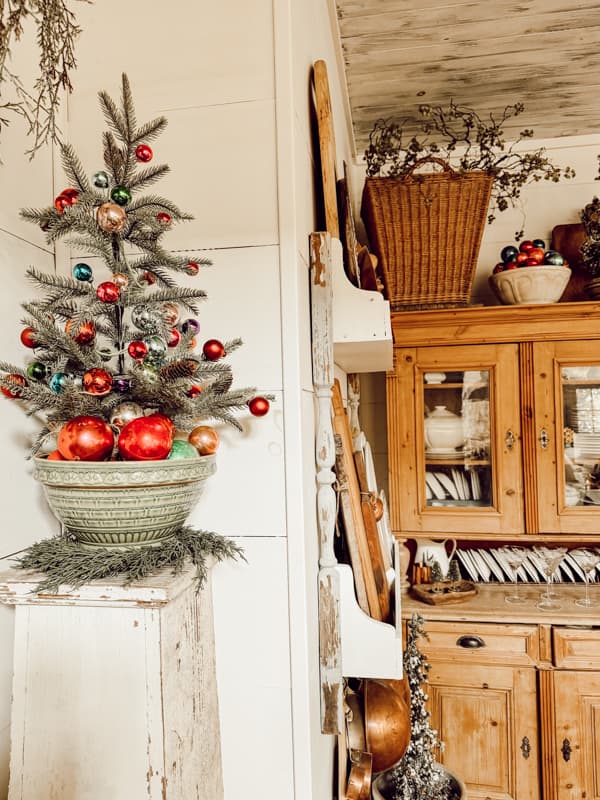 Antique bowl filled with vintage glass  Christmas Ornaments and Christmas tree.  