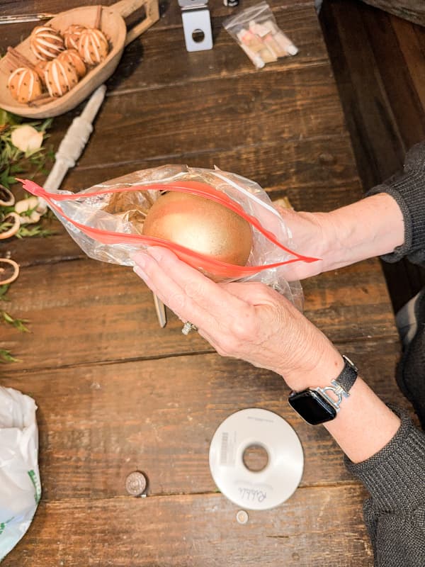 Roll Dollar tree ornament in plastic bag until covered in Rub N Buff