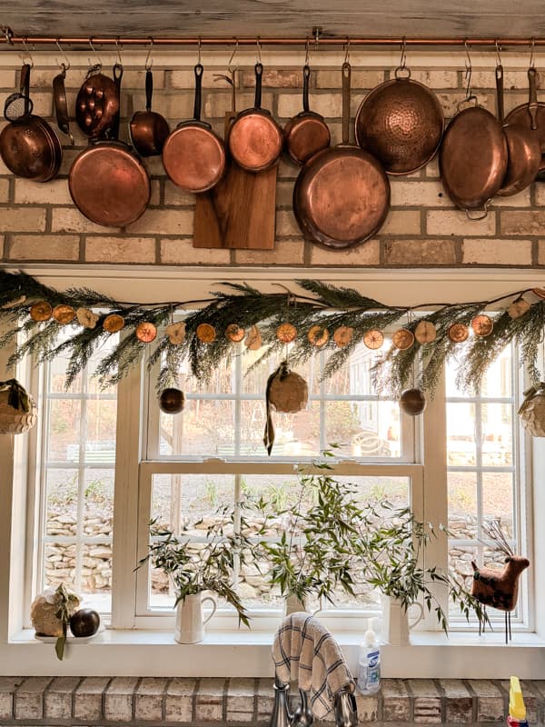 Dried Fruit Garland with oranges and pears on greenery garland in kitchen window