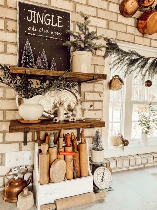 Open shelving with DIY Christmas Jingle Bell Sign and DIY reindeers and Old rolling pins.