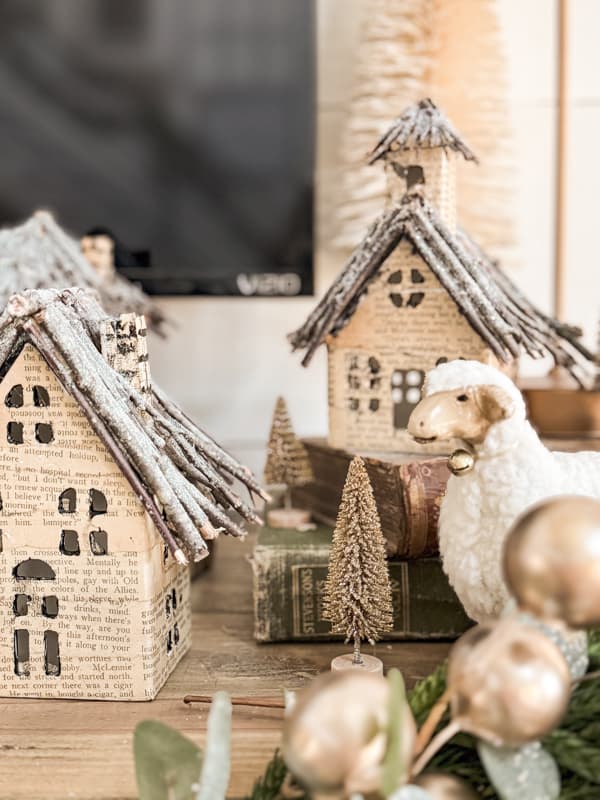 DIY old book page upcycled Christmas village with bottle brush trees and sheelp. 