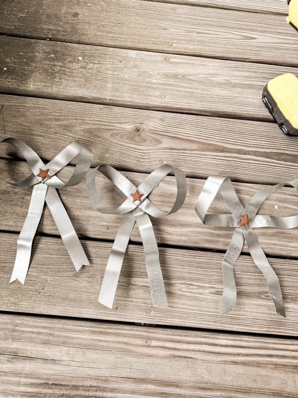 three Christmas tree bows made of metal