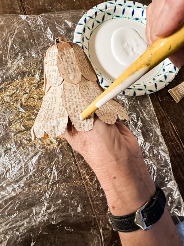 Add glue dot to christmas bells with brush handle.