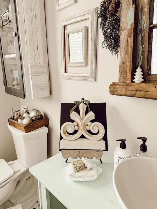 Old architectual element on black canvas for Christmas art on bathroom vanity