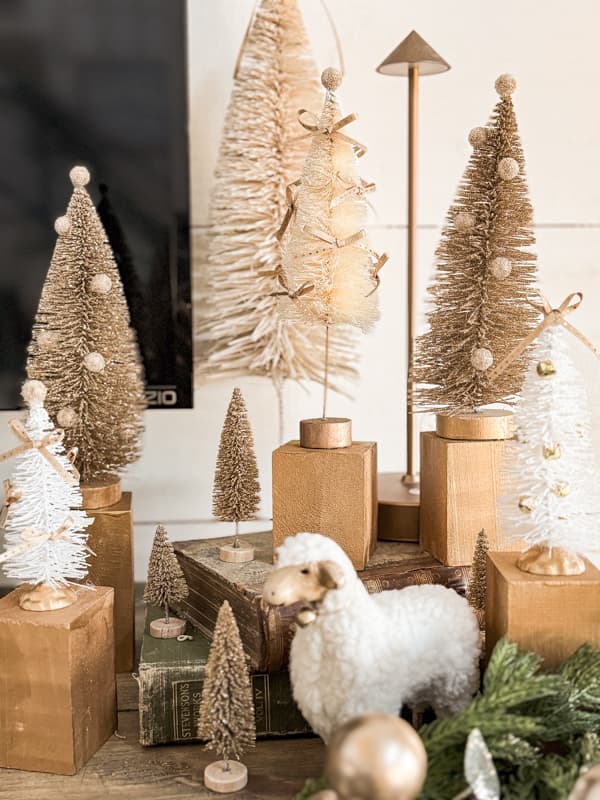 Add gold jingle bells to white tree and add to a grouping of updated inexpensive trees for a designer vignette.  