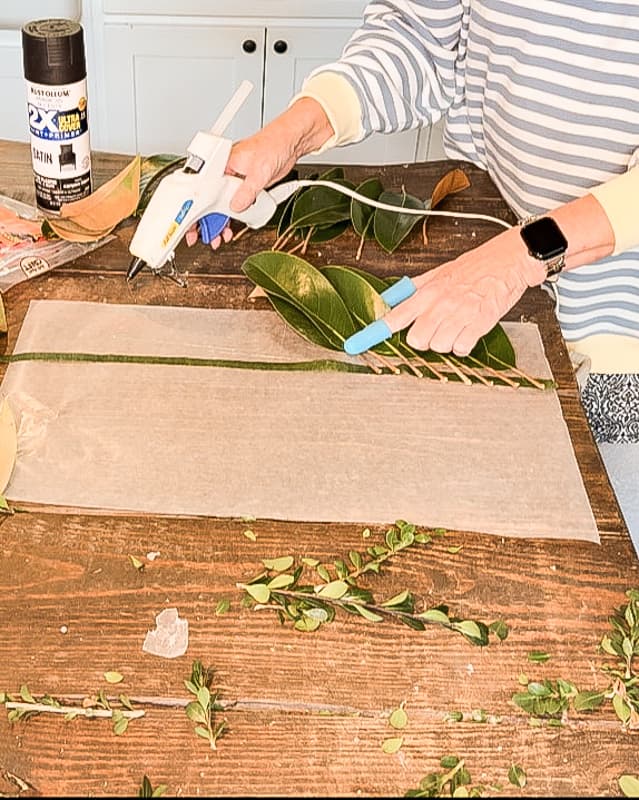 Rows of Magnolia leaves attached with floral tape and hot glue