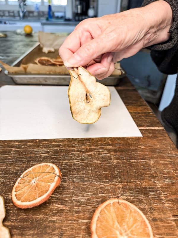 Add dried pears to wire for garland 