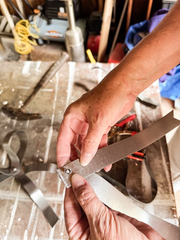 Add nut and bolt to create Christmas bow with metal strapping.