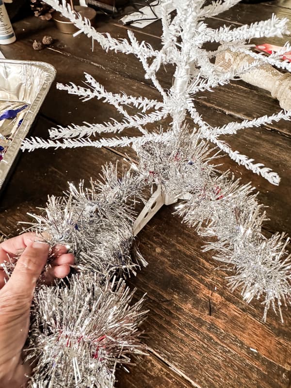 Wrap silver tinsel around the bare tree branches to make a Faux Vintage Aluminum Christmas Tree