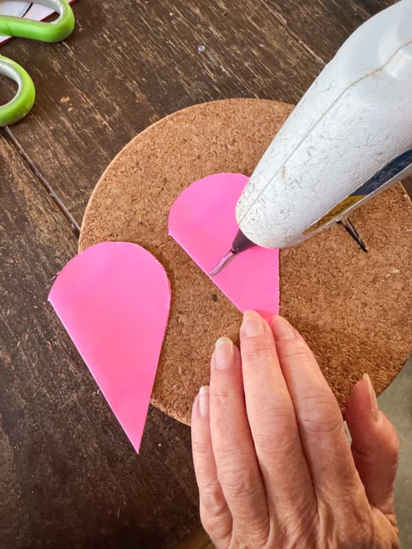 add hot glue to hold folder paper hearts together for Valentine's Day Decoration