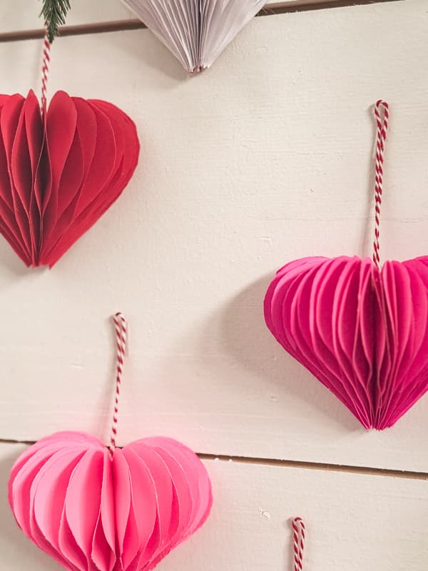 Valentine's Day Decoration 3D paper hearts hanging on wall with a thrift store frame.