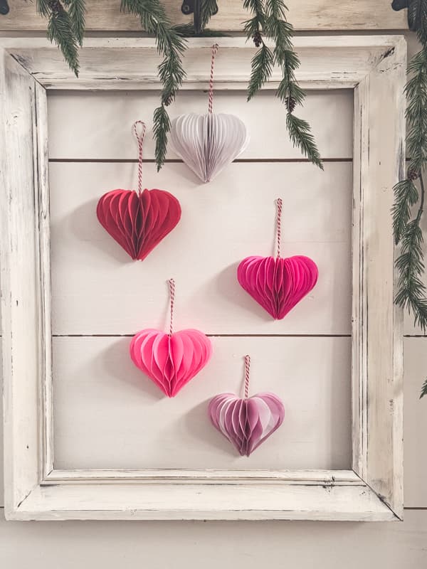 Valentine's Day Decoration 3D paper hearts hanging on wall with a thrift store frame.